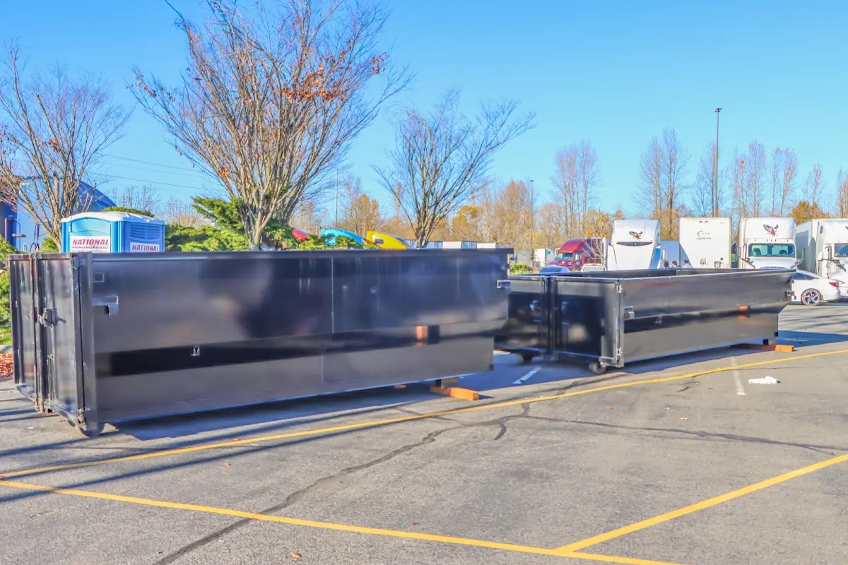 Professional dumpster rental service with roll-off container on residential driveway in West Slope